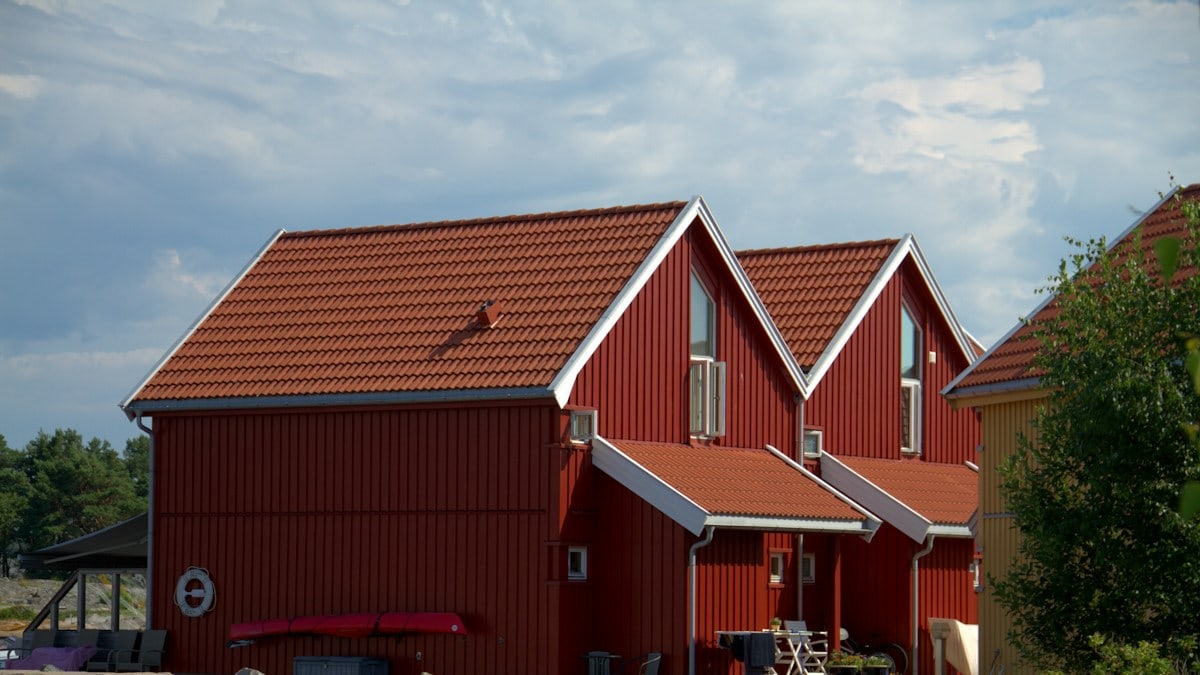 Red houses sit beside a stone wall